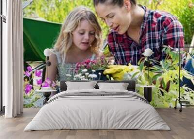 Mother and daughter gardening together in garden Wall mural