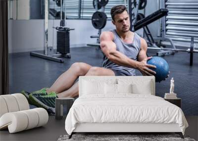 muscular man doing russian twist exercises Wall mural