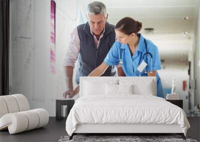 Nurse helping senior man with walking aid Wall mural