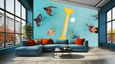 Overhead of happy diverse friends playing fun game of volleyball in sunny swimming pool, copy space Wall mural