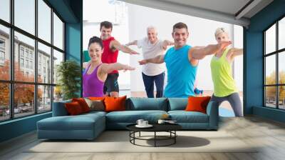 People doing warrior pose in yoga class Wall mural