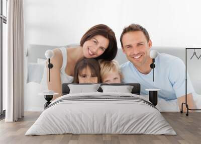 Portrait of a happy family sitting on the bed Wall mural