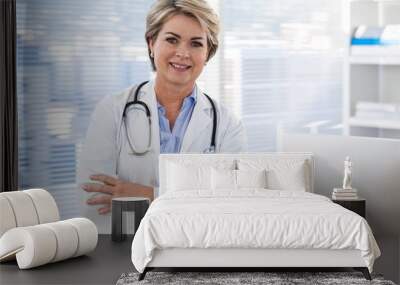 Portrait of a smiling female doctor standing with arms crossed Wall mural