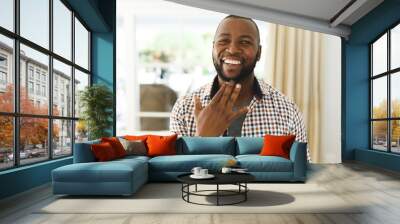 Portrait of african american man smiling and looking at camera in living room talking sign language Wall mural