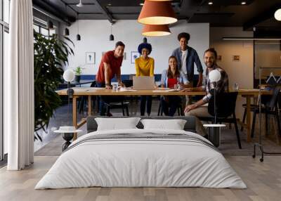 Portrait of diverse male and female colleagues using laptop and tablet in casual office meeting Wall mural