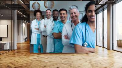 Portrait of group of diverse male and female doctors standing in hospital corridor smiling to camera Wall mural