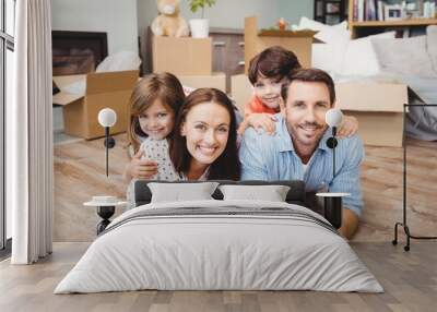 Portrait of happy family lying on hardwood floor Wall mural