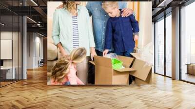 Portrait of happy family opening boxes Wall mural