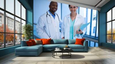 Portrait of male and female doctors standing in corridor Wall mural