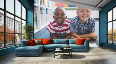 Portrait of school kids reading book in library Wall mural