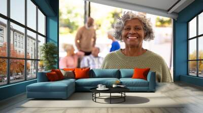 Portrait of smiling african american senior woman standing with multiracial friends in background Wall mural