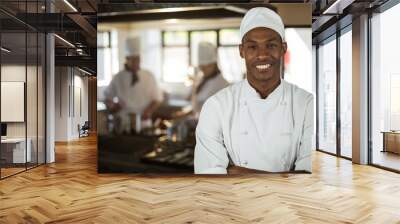 Portrait of smiling chef standing with arms crossed Wall mural