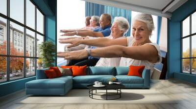 Portrait of smiling senior woman exercising with friends Wall mural