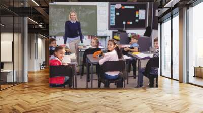 Portrait of smiling teacher and schoolkids in classroom Wall mural