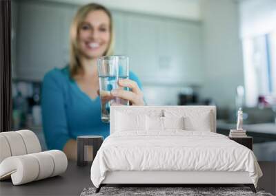 Pretty blonde woman drinking a glass of water Wall mural