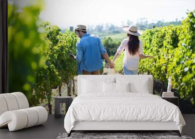 Rear view of couple walking at vineyard Wall mural