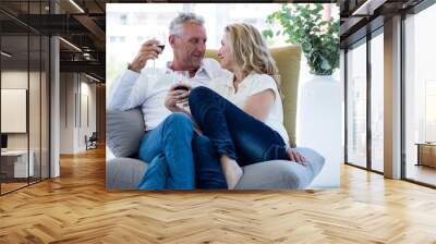 Romantic mature couple having red wine at home Wall mural