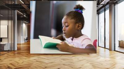 School girl reading book in classroom Wall mural