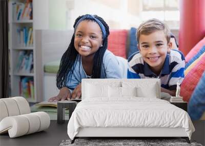 School kids lying on sofa and reading book Wall mural