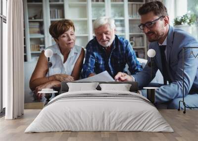 Senior couple planning their investments with financial advisor Wall mural