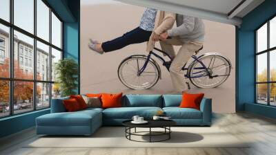 Senior man with senior woman riding bicycle on the beach Wall mural