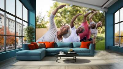 Senior people looking up while exercising with arms raised Wall mural