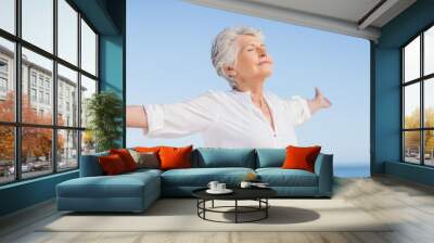 Senior woman relaxing on the beach Wall mural