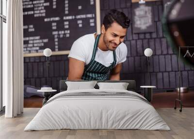 Smiling barista cleaning counter Wall mural