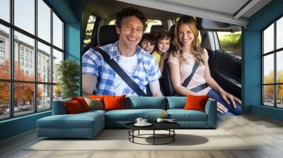 Smiling family sitting in the car Wall mural