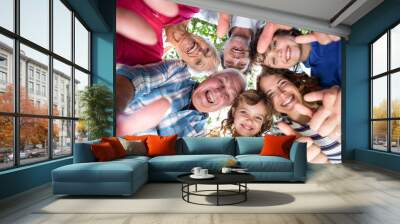 smiling family standing in a circle Wall mural