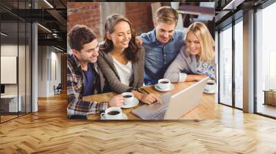 Smiling friends drinking coffee and using laptop Wall mural