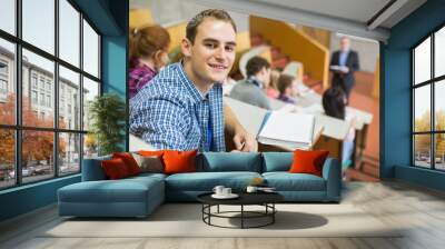 Smiling male with students and teacher at lecture hall Wall mural