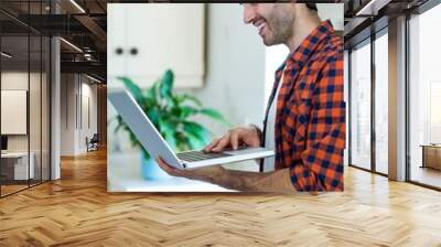 Smiling man using laptop Wall mural