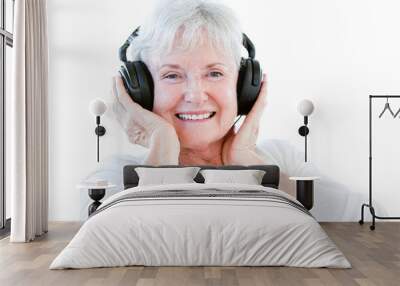 Smiling senior woman listening music with headphones Wall mural