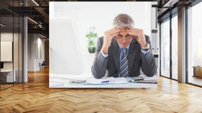 stressed businessman with head in hands Wall mural