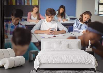 Student using mobile phone in classroom Wall mural