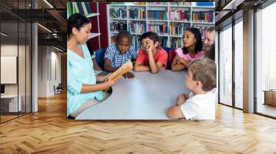 teacher reading a book to mixed race children Wall mural