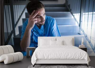 tensed male nurse sitting on staircase Wall mural