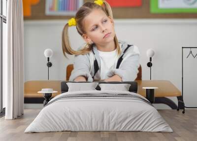 Thoughtful pupil sitting at her desk in a classroom Wall mural