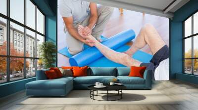 trainer working with man on exercise mat Wall mural