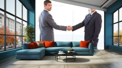 two charismatic businessmen shaking hands standing in the office Wall mural