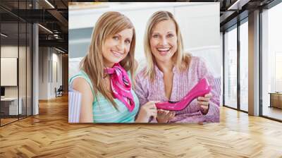 two delighted women with shopping bags showing a pink shoe at ho Wall mural