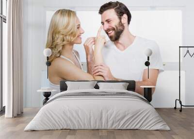 Woman applying cream to her man Wall mural