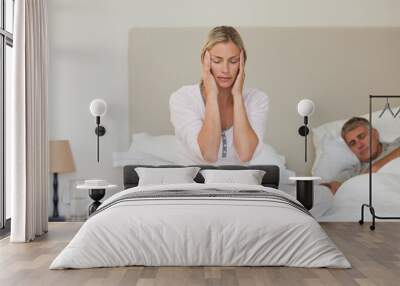 Woman having a headache while her husband is sleeping Wall mural