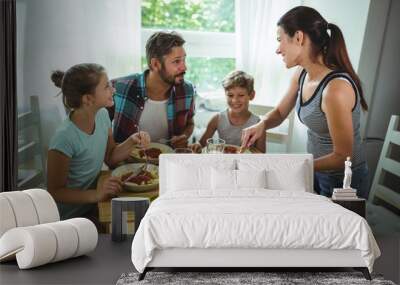 Woman serving meal to her family Wall mural