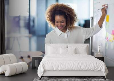 woman writing on whiteboard while holding digital tablet Wall mural