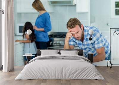 Worried father looking at bills at home Wall mural