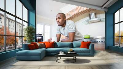 Young man leaning on the table holding coffee mug Wall mural