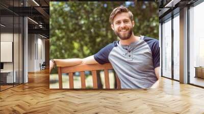 Young man relaxing on park bench Wall mural