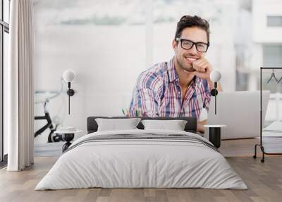 Young man sitting at his desk Wall mural